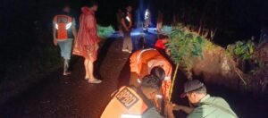 Petugas BPBD meninjau senderan jalan yang longsor di Banjar Munduk Anggrek