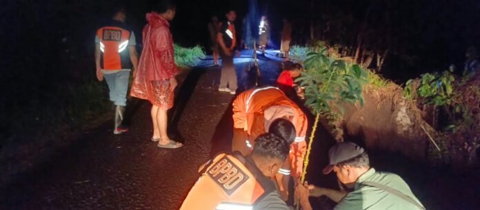 0178544454e69bff073051e3b96ab1a9583f5204b2ff205b8db6506de167dbd8 Petugas BPBD meninjau senderan jalan yang longsor di Banjar Munduk Anggrek
