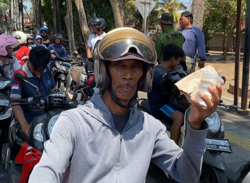 Pengantre BBM Gusti Ardana menerima nasi bungkus gratis di SPBU TMP