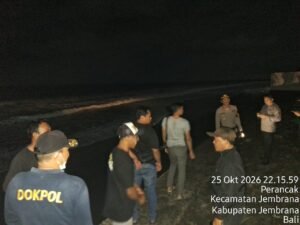 Petugas polisi di Pantai Perancak malam hari usai insiden dua remaja terseret arus