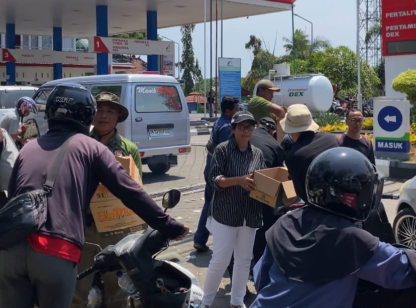 Relawan membagikan nasi bungkus gratis kepada pengantre BBM di SPBU TMP Jembrana