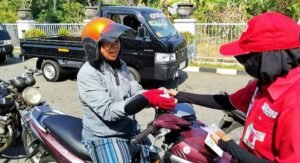 Petugas SPBU Jembrana membagikan air mineral gratis kepada pengendara yang antre BBM