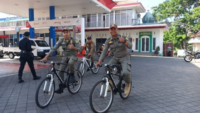Petugas Satpol PP patroli di SPBU saat antrean BBM melandai di Jembrana
