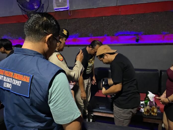 Petugas Polres Jembrana memeriksa barang bawaan pengunjung kafe saat Operasi Sarang Narkoba