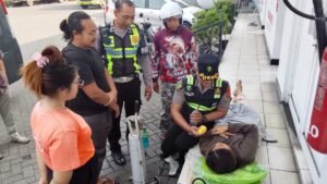 Petugas Dokkes Polres Jembrana memberikan pertolongan pertama kepada IRT yang kejang saat antre BBM