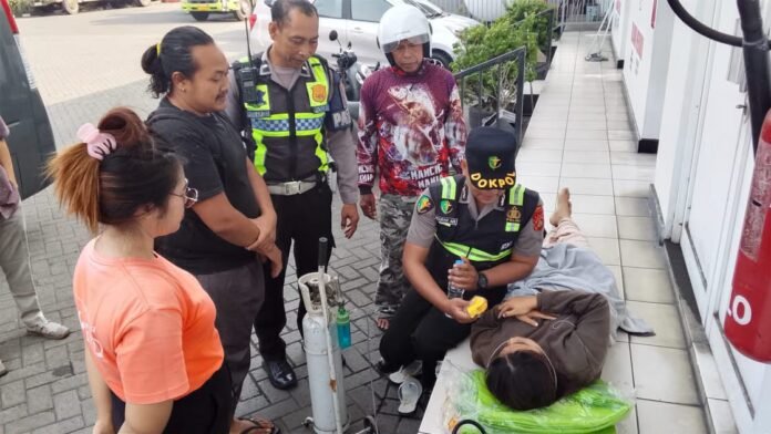 Petugas Dokkes Polres Jembrana memberikan pertolongan pertama kepada IRT yang kejang saat antre BBM